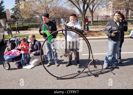 Homme debout à côté d'une grande roue de vélo roue Banque D'Images