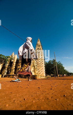 Une femme marche par la grande mosquée de Bobo Dioulasso. Banque D'Images