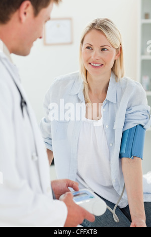 Smiling woman getting sa pression artérielle mesurée Banque D'Images