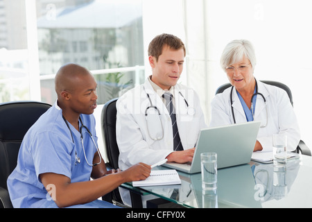 Doctors sitting in meeting room with a laptop Banque D'Images