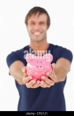 Tirelire tenu par un jeune homme Banque D'Images