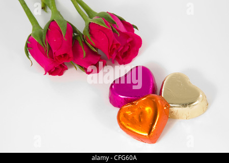 Coeur chocolat et rose dans le jour de la Saint-Valentin, fond blanc Banque D'Images