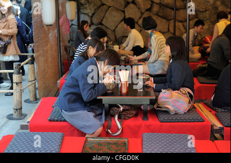 Ecolières eating noodles dans le restaurant de style Japonais au temple Kiyomizu-dera, Kyoto, Japon Banque D'Images