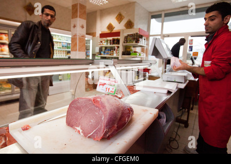 Un boucher sert un client de la viande halal dans un supermarché Halal à Nantes, France. Banque D'Images