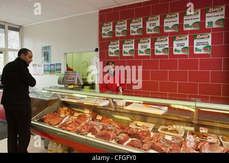 Un boucher sert un client de la viande halal dans un supermarché Halal à Nantes, France. Banque D'Images