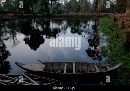 Réflexion dans les douves et vieux bateau de rangée, Prasat Krahom (Temple Rouge), Koh Ker, province de Preah Vihear, Cambodge. © Kraig Lieb Banque D'Images