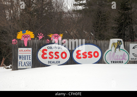 Signes sur une clôture font partie d'un affichage de vieilles enseignes et pompes à essence en face d'une maison dans le New Hampshire Banque D'Images