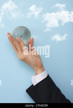 Businessman's hand holding Glass globe Banque D'Images