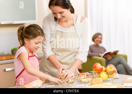 Mère et fille, ce qui fait d'apple pie ensemble la recette grand-mère Banque D'Images