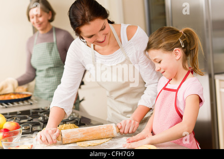 Jeune fille préparer la cuisson de la tarte aux pommes avec la mère et grand-mère Banque D'Images