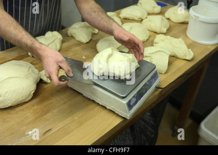 Un Atisan baker pèse la pâte à pain Banque D'Images