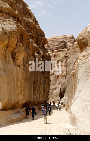 Petra. La Jordanie. Avis de touristes marcher dans l'étroit ravin appelé le siq qui donne une introduction et Banque D'Images