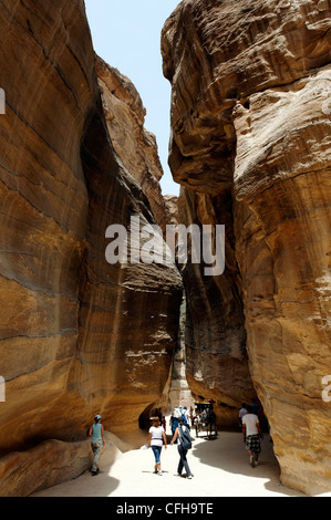 Petra. La Jordanie. Avis de touristes marcher dans l'étroit ravin appelé le siq qui donne une introduction et Banque D'Images