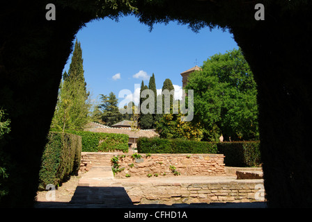 Vue à travers les jardins une haie avec le Parador de san francisco à l'arrière, le palais de l'Alhambra, Grenade, Espagne, Europe. Banque D'Images