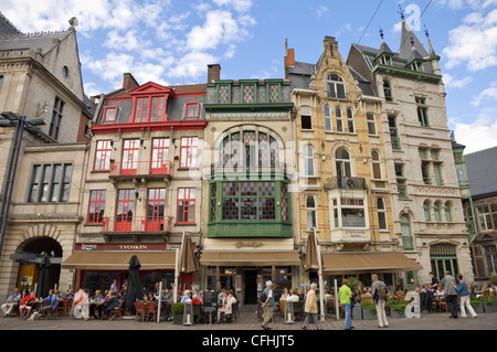 Vue horizontale de gens assis à cafés à l'architecture traditionnelle à St Baafsplein aka St Bavo's Square dans le centre de Gand, Belgique Banque D'Images