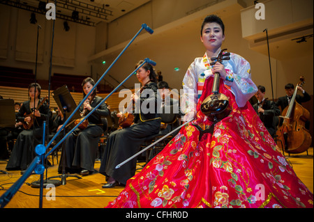 Paris, France, Orchestre symphonique de Corée du Nord 'l'Orchestre Unhasu' avec 'l'Orchestre Philharmonique de radio France' interprète Premier concert en Europe Femme Performer en robe traditionnelle, dans la salle Playel Theatre, faire de la musique ensemble Banque D'Images