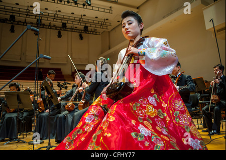 Paris, France, l'Orchestre symphonique de Corée du Nord « l'Orchestre Unhasu » et « l'Orchestre Philharmonique de radio France » exécutent le Premier concert en Europe, dans la salle Playel Theatre, Woman Performer dans la robe traditionnelle sur scène tenant un instrument traditionnel. INSTRUMENTS DE JEU CORÉENS Banque D'Images