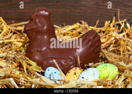 Still Life photo d'une poule chocolat assis sur un mangeur de bonbons mouchetée couverts d'œufs. Banque D'Images