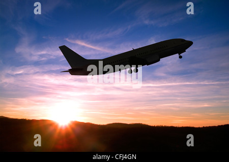 Avion décollant dans un coucher de soleil. Banque D'Images