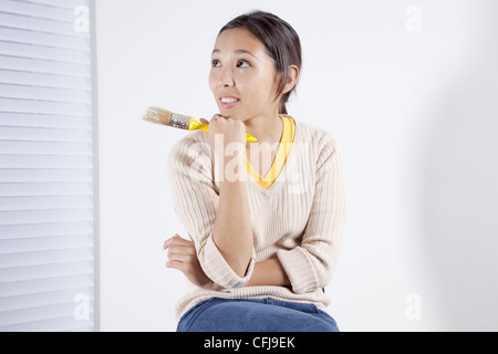 Jeune femme tenant un pinceau peinture Banque D'Images