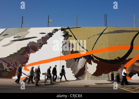 Les visiteurs du parc olympique de Stratford 2012 passer devant une oeuvre murale. Banque D'Images