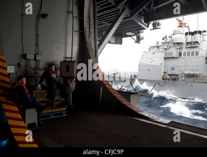 Les marins regardent le porte-avions USS Enterprise (CVN 65) ravitailler le croiseur à missiles guidés USS Vicksburg (CG 69). Enterprise est déployé dans le cadre du groupe Enterprise Carrier Strike pour soutenir les opérations de sécurité maritime et les efforts de coopération en matière de sécurité dans les zones de responsabilité de la 5e et de la 6e flotte américaine. Banque D'Images