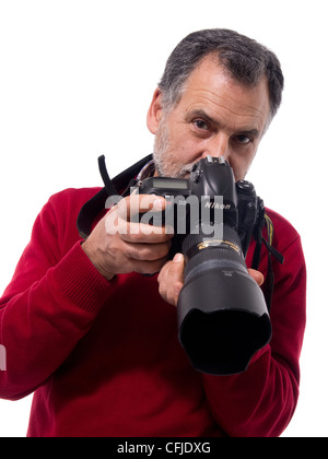 Portrait d'homme mature tenant un appareil photo reflex numérique sur fond blanc Banque D'Images