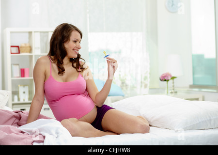 Photo de happy pregnant woman holding sucette Banque D'Images