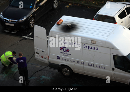 Les hommes de l'équipe de graffiti Renfrewshire Council à Paisley, Écosse à essayer d'enlever la peinture de la route renversé Banque D'Images