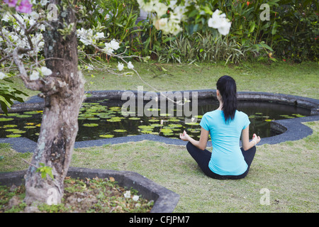 Woman practicing yoga at Taman Tirta Gangga (eau Palace), Tirta Gangga, Bali, Indonésie, Asie du Sud, Asie Banque D'Images