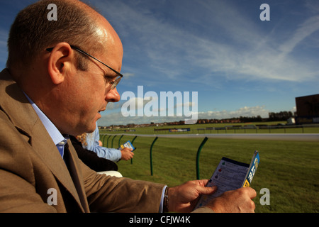 L'étude de l'homme formule avant une course de chevaux à l'Ayr Gold Cup Ecosse à Ayr course hippique. Banque D'Images