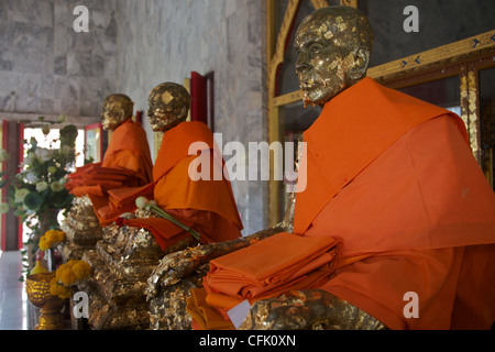 Des statues de moines au célèbre Wat Chalong, Phuket, couverts de feuilles d'or Banque D'Images