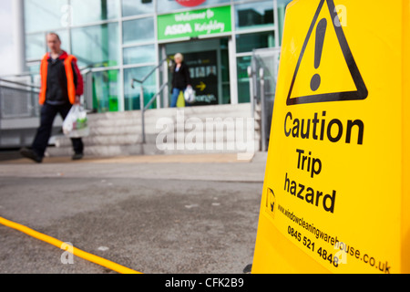 Un trébuchement signe par un tuyau flexible à l'extérieur de l'Asda Keighley, West Yorkshire, Royaume-Uni. Banque D'Images