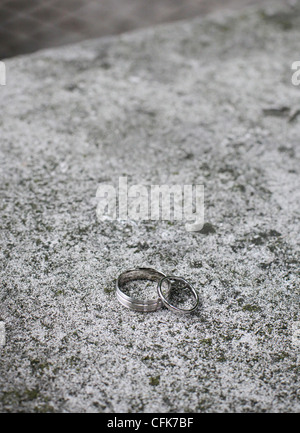 Les anneaux de mariage sur une surface en béton. Banque D'Images