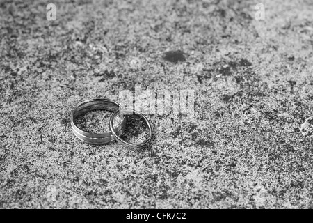 Les anneaux de mariage sur une surface en béton. Banque D'Images