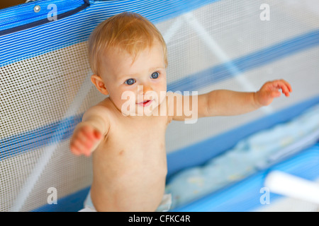 Joli bébé jouant dans un parc pour enfants Banque D'Images