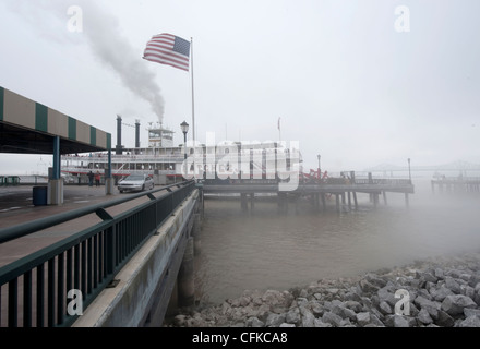 Un bateau à aubes dans la brume du fleuve Mississippi à la Nouvelle Orléans avec les stars and stripes drapeau sur le pont. Banque D'Images