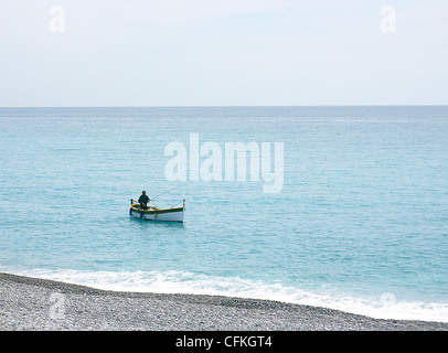 Pêche à l'homme seul dans un petit bateau blanc sur la mer de la Méditerranée par beau temps à Nice, France Banque D'Images