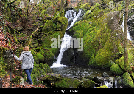 Woman descendre un chemin glissant près de Stock Ghyll vigueur chutes d'Ambleside Cumbria Lake District UK Banque D'Images