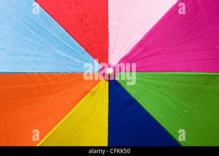 Close up d'un parapluie multicolore sous la pluie. Banque D'Images