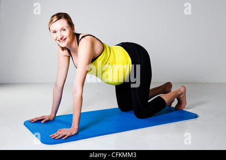 Femme enceinte dans une position à genoux en quatre points prêt à exercer ses muscles du tronc de base Banque D'Images