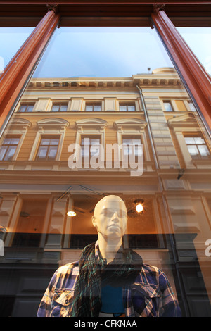 Image d'orientation verticale est mannequin derrière la fenêtre avec la réflexion de construction à Riga, Lettonie. Banque D'Images