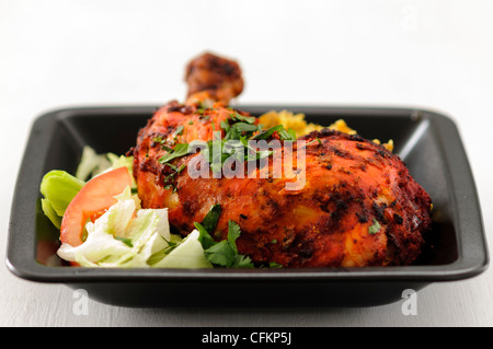 Repas de poulet tandoori et riz au safran salade sur plaque noire garni de coriandre hachée Banque D'Images