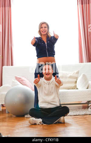 Happy pregnant woman avec mari dans sport wear showing Thumbs up Banque D'Images