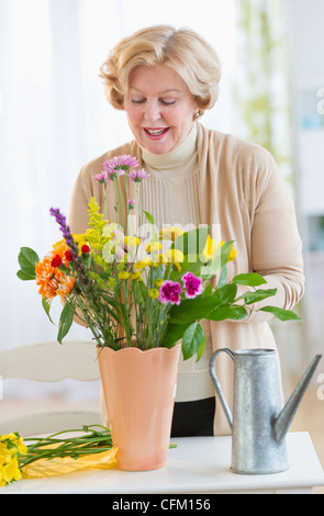 USA, New Jersey, Jersey City, senior woman arranging flowers Banque D'Images