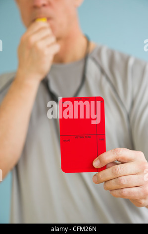 Arbitre masculin montrant carte rouge, studio shot Banque D'Images