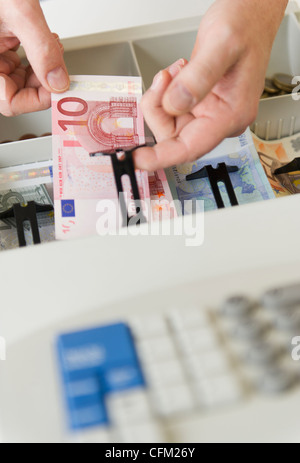 Close up de la main de l'homme mettant en billets de caisse, studio shot Banque D'Images