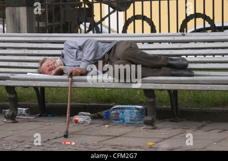 Un homme sans-abri dormir sur le banc dans la rue de Moscou, Russie Banque D'Images