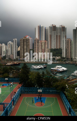 Jouer au basket-ball par Aberdeen Harbour et le quartier de Hong Kong. Banque D'Images