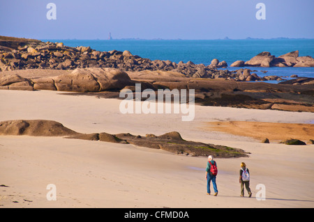 Deux personnes marchant le long de la plage, à Ploumanach, Cotes d'Armor, Bretagne, France, Europe Banque D'Images